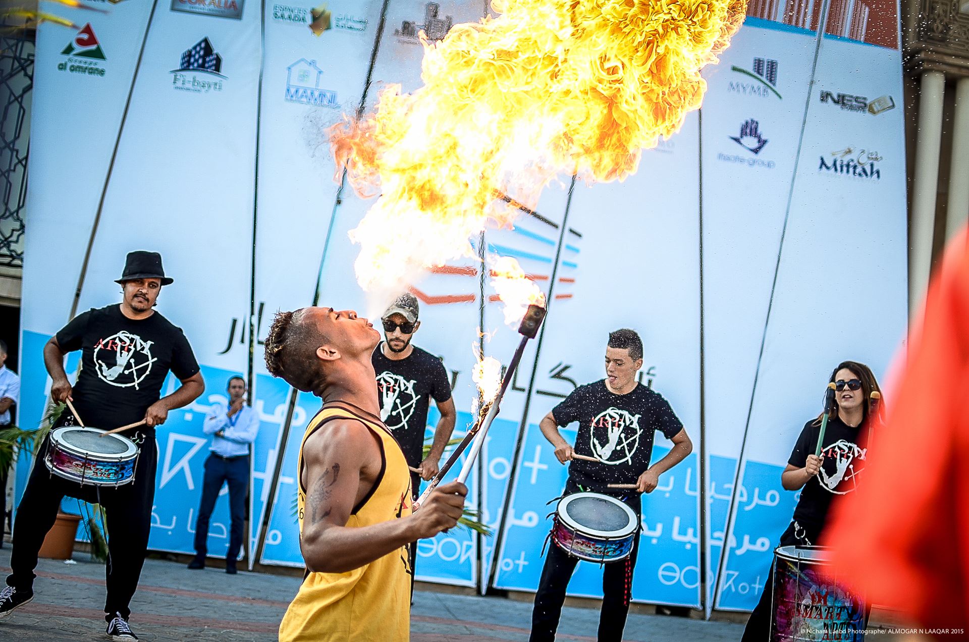 Cracheur de feu entouré de percussionnistes lors du Salon Almogar N'Laaqar à Agadir