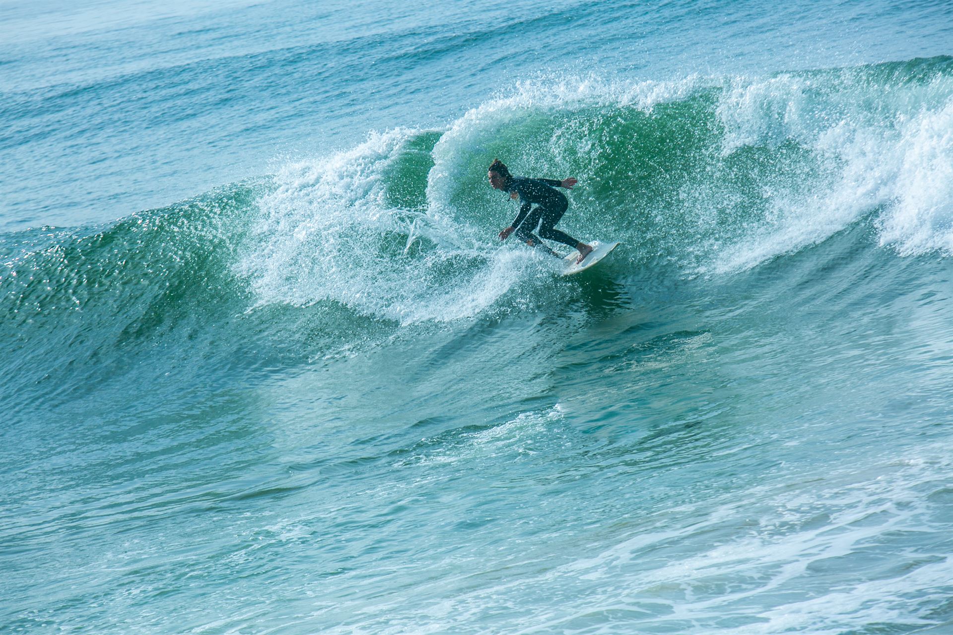 Surfeur au cœur d'une vague turquoise lors de l'événement TSE à Taghazout